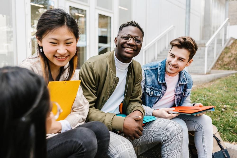three smiling students sitting